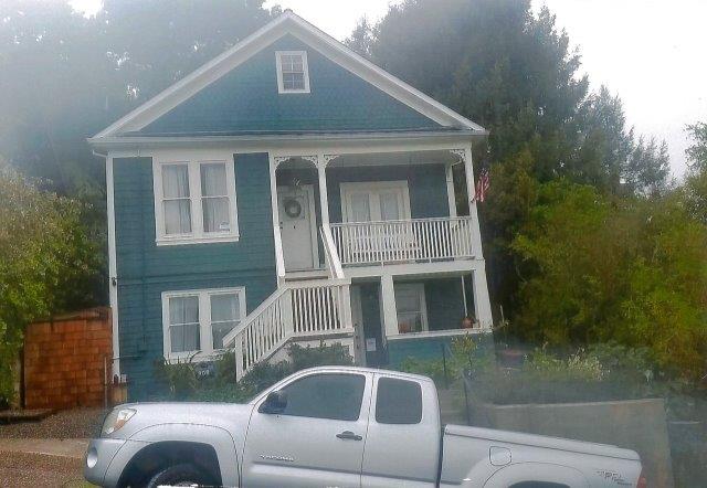 After: Unobstructed view of house with repaired retaining wall at sidewalk.